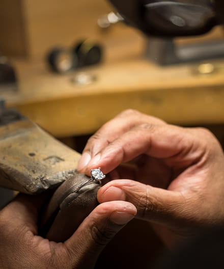 artisan crafting a Blue Nile diamond ring by hand